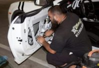 Technician repairing power window regulator in car door